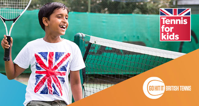 Child smiling with a raccket in a tennis for kids shirt