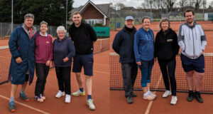 8 players four men and four women representing Wells Tennis Club standing as a team on a Clay court